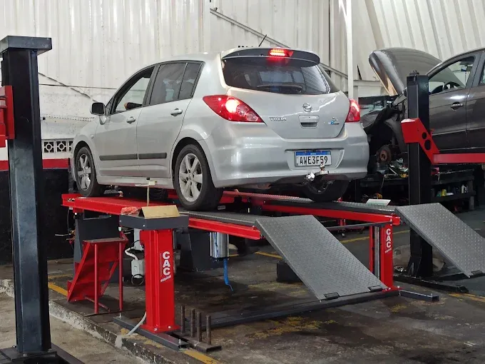 Carro prata sobre o elevador de alinhamento 3D da oficina