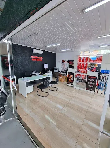 Recepção da oficina Máxima Prime Auto Center com balcão branco e prateleiras de produtos